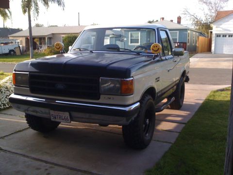 1989 Ford Bronco - This pickup truck features a two-tone paint scheme and custom smiley face side mirrors.