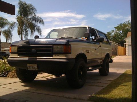 1989 Ford Bronco - This 1989 Ford Bronco is shown in a two-tone paint scheme with a dark blue hood and upper body over a cream lower body.
