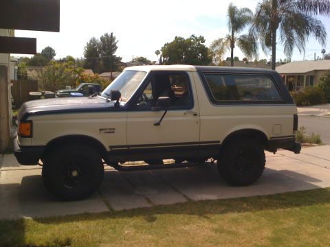1989 Ford Bronco - Side view of a 1989 Ford Bronco parked on a concrete driveway.