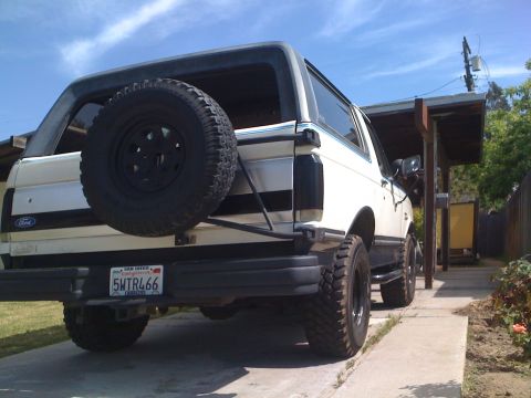 1989 Ford Bronco - Rear view of a white Ford Bronco parked on a concrete driveway under a carport.