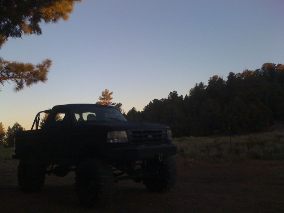 Lifted pickup truck with large tires parked outdoors during the day