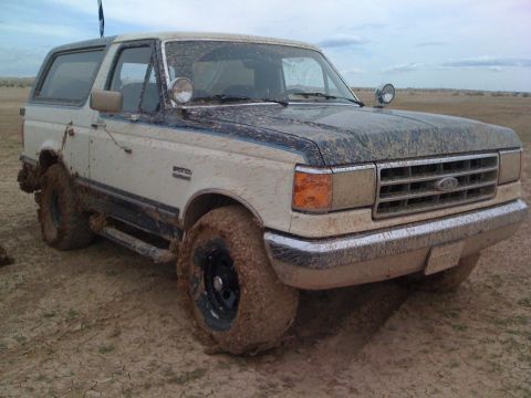 1989 Ford Bronco - This off-road vehicle is covered in mud after a drive through a rough terrain.