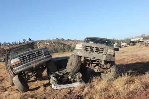 1992 Ford Bronco and another Ford truck off-roading, one on top of the other