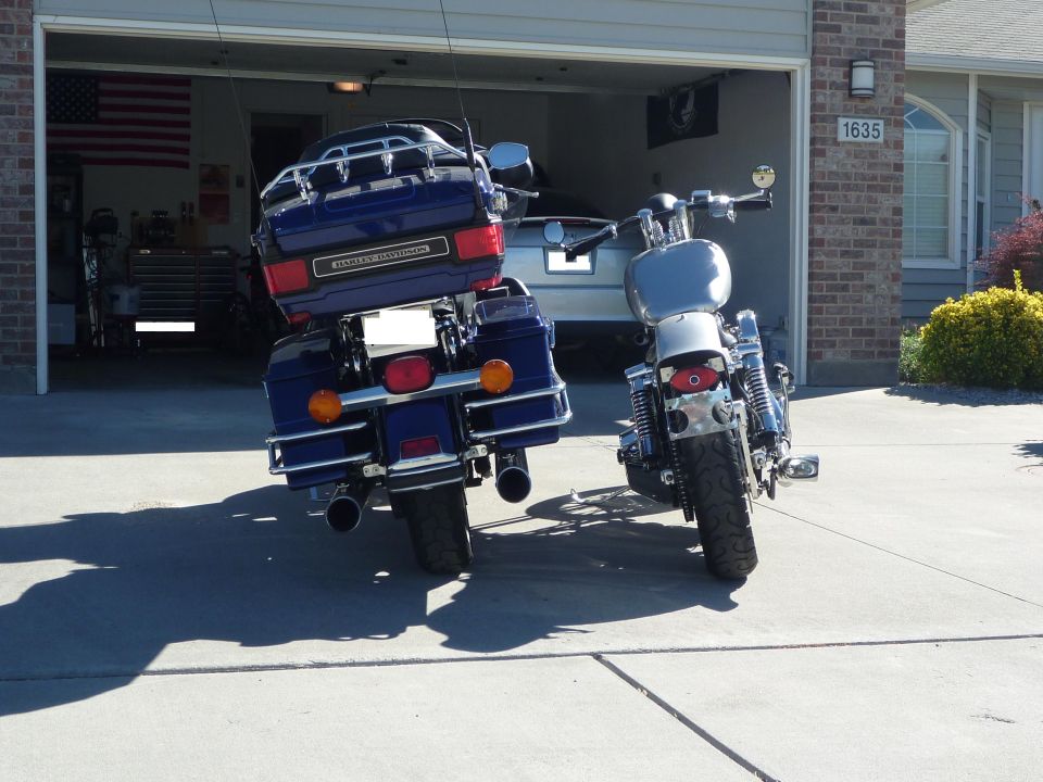 Rear view of blue Harley-Davidson motorcycle with a silver one beside it