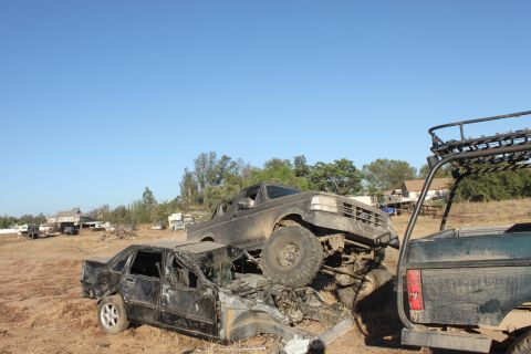 1992 Ford Bronco on top of a crushed car, front 3/4 view