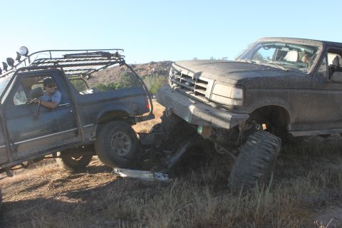 1992 Ford Bronco and another truck stuck together off-road