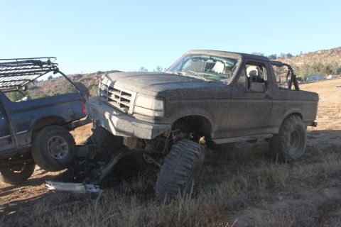 1992 Ford Bronco stuck in dirt next to another Bronco with a roof rack