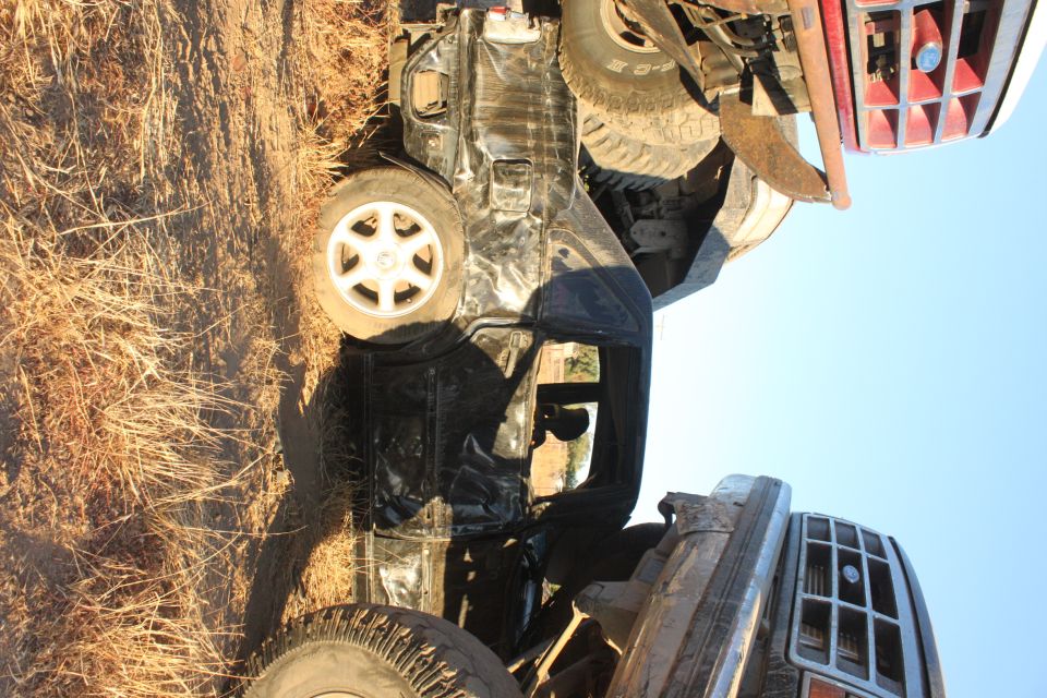 Overturned 1992 Ford Bronco on its side in dry grass