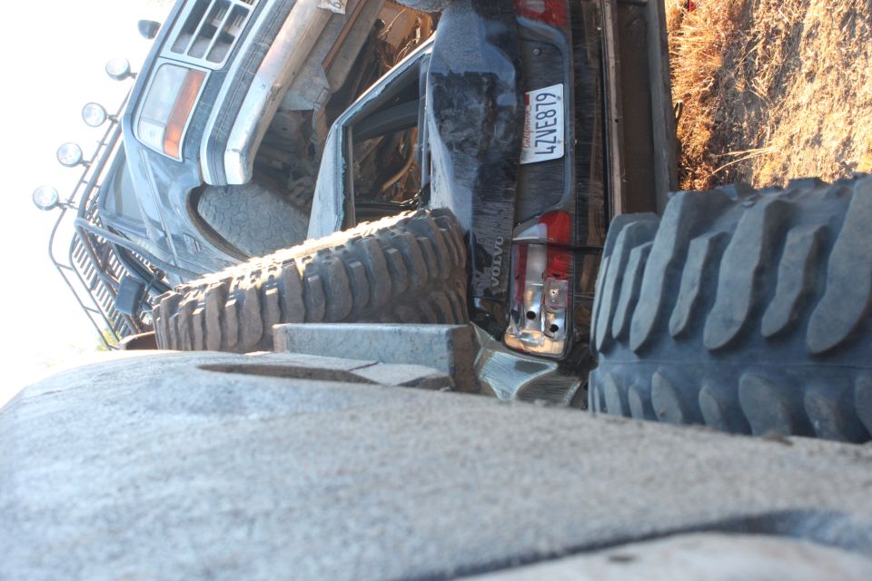 off-road truck with large tires, license plate 4ZVE879, and 'VOLVO' text on the rear