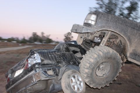 Large truck crushing a sedan, both heavily damaged