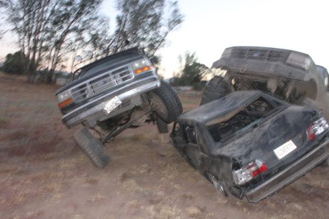 1992 Ford Bronco and two other wrecked vehicles on dirt