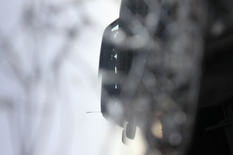 Close-up of a vehicle's side mirror and part of the door frame, out of focus