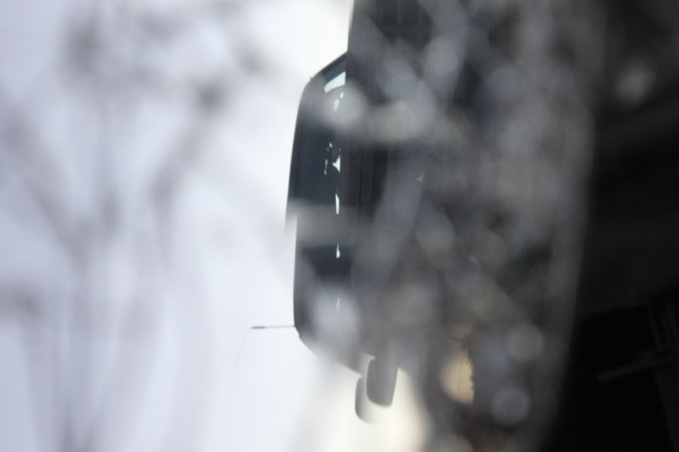 Close-up of a vehicle's side mirror and part of the door frame, out of focus