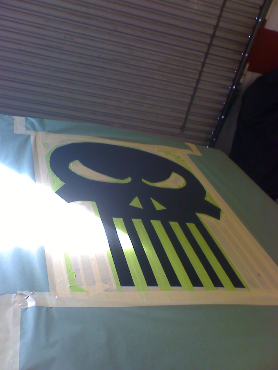 skull graphic with green stripes taped onto a surface