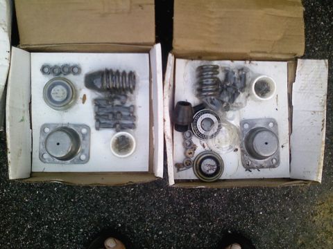 1990 Ford Bronco - Assorted suspension components are laid out in two cardboard boxes, ready for installation or inventory.