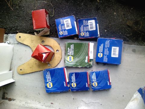 1990 Ford Bronco - Various automotive parts, including NAPA oil seals and bearings, are laid out on a concrete surface.