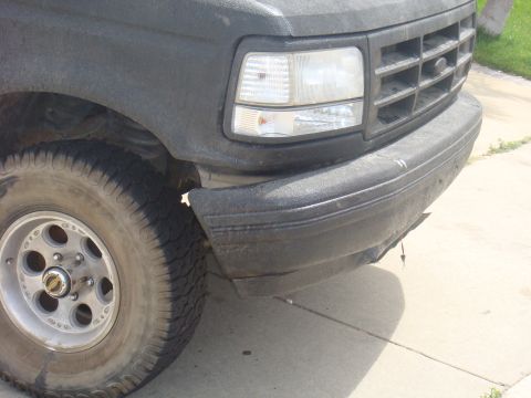 1992 Ford Bronco - Front corner view of a 1992 Ford Bronco, showing the headlight, grille, and bumper.