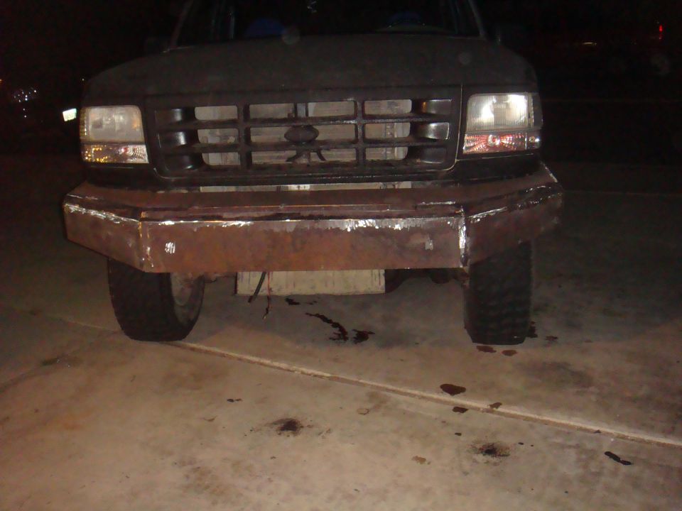 Dark 1992 Ford Bronco with a custom rusty metal bumper and a grille visible