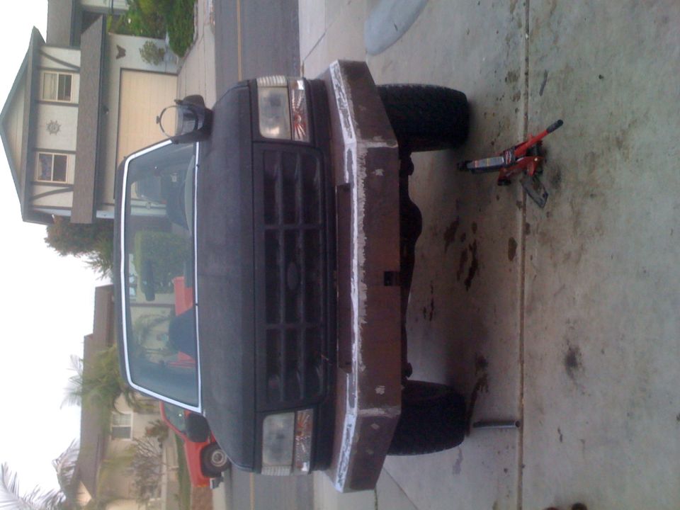 Black 1992 Ford Bronco front view, custom bumper, jack under front tire