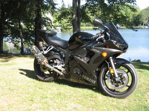 2008 Yamaha R1 - Black Yamaha R6 motorcycle parked on grass by a lake, with trees and water in the background.