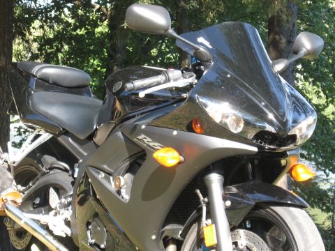 2008 Yamaha R1 - A black Yamaha R6 motorcycle is shown from the front, parked in a grassy area with trees in the background.