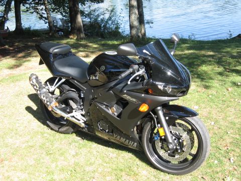 2008 Yamaha R1 - Black Yamaha R6s motorcycle parked on grass next to a body of water.