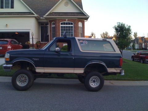 1992 Ford Bronco - This lifted Ford Bronco is parked on a suburban street in front of a residential home.