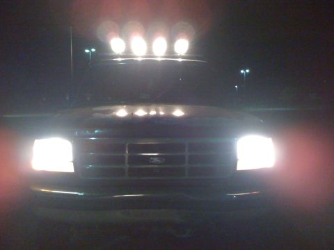 1992 Ford Bronco - Front view of a 1992 Ford Bronco at night, with its headlights and roof lights on.