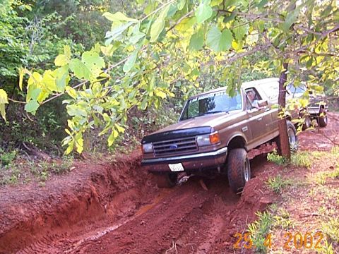 1986 Ford Bronco - This 1987 Ford Bronco navigates a challenging off-road path, followed by another vehicle, highlighting its capabilities.