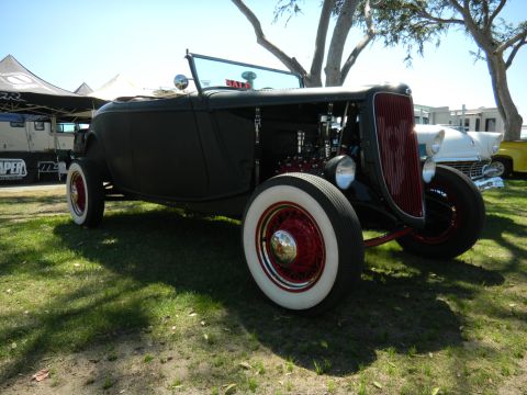 1997 Ford Ranger - A black hot rod convertible with a prominent red grille and whitewall tires is parked on grass.