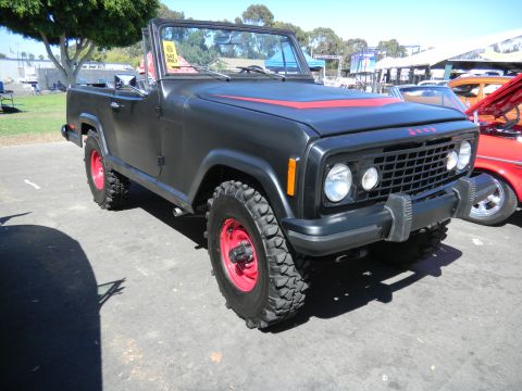 1997 Ford Ranger - A black Jeep CJ-8 Scrambler with red accents and off-road tires is parked outdoors next to another vehicle.