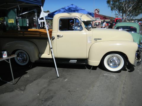 1997 Ford Ranger - A cream-colored 1950 Chevrolet 3100 pickup truck is parked at an outdoor event, with another vehicle visible behind it.