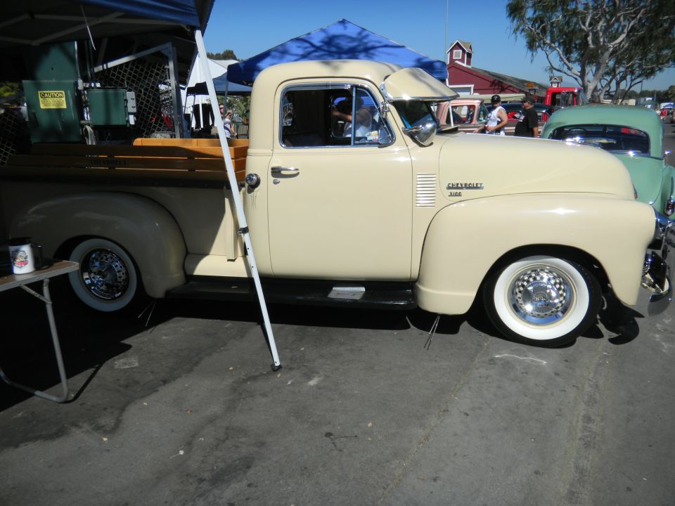 Cream 1950 Chevrolet 3100 pickup truck with chrome hubcaps and whitewall tires