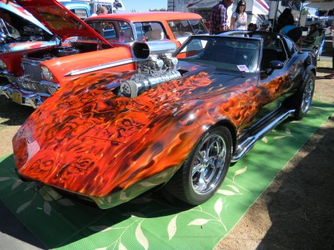 1997 Ford Ranger - A heavily customized car with a flame paint job and a supercharger sits on display at an outdoor event.