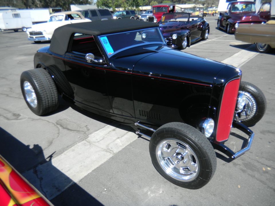 Black hot rod convertible with red grille and wide rear tires