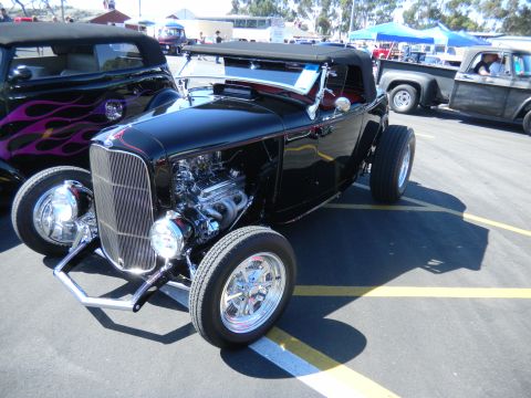 1997 Ford Ranger - A black hot rod with a prominent chrome grille and exposed engine is parked at an outdoor event.