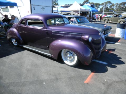 1997 Ford Ranger - A custom purple coupe with vintage styling is displayed at an outdoor car show.