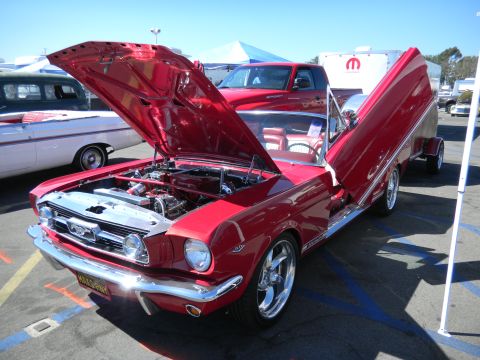 1997 Ford Ranger - A red 1965 Ford Mustang convertible is displayed with its hood and gullwing doors open, revealing custom modifications.