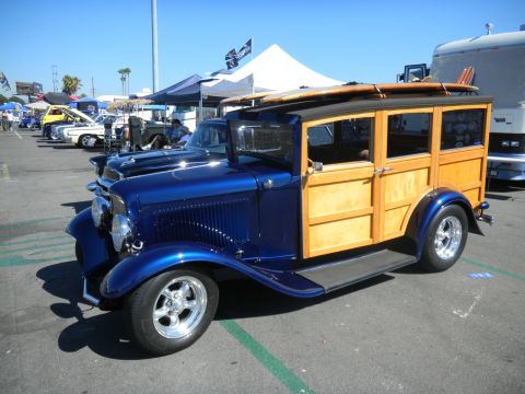 1997 Ford Ranger - A classic woodie station wagon with surfboards on its roof is parked at an outdoor car show.
