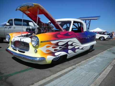 1997 Ford Ranger - A custom hot rod with a vibrant flame paint job and a powerful exposed engine is displayed at an outdoor event.