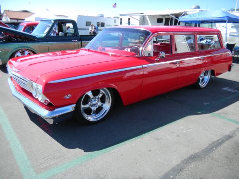 1997 Ford Ranger - A red 1962 Chevrolet Nomad station wagon is parked next to a pickup truck at an outdoor event.