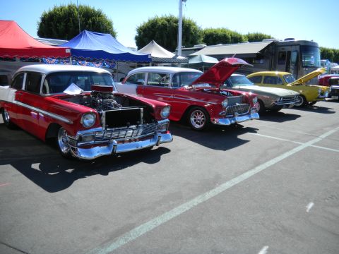 1997 Ford Ranger - A line of vintage automobiles are displayed outdoors, with tents and an RV visible behind them.
