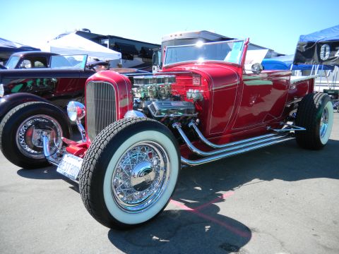 1997 Ford Ranger - A red hot rod with a large V8 engine and whitewall tires is displayed outdoors.