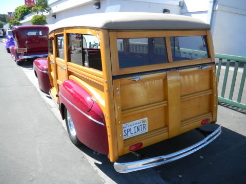1997 Ford Ranger - A classic woodie station wagon is seen from the rear, parked in a line with other vehicles.