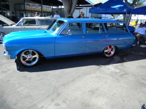 1997 Ford Ranger - A blue station wagon is parked next to another vehicle at an outdoor event.