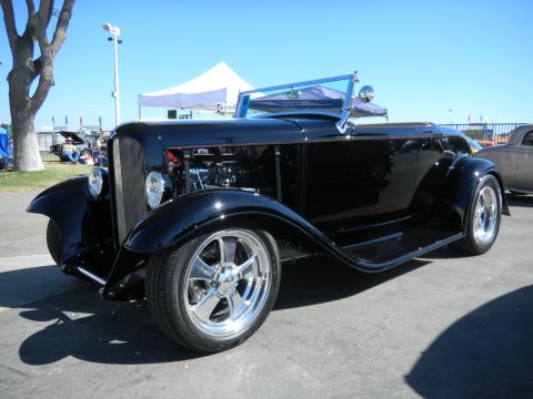 1997 Ford Ranger - A black hot rod convertible with a polished grille and chrome wheels is displayed outdoors.