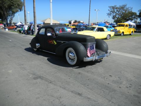 1997 Ford Ranger - A black hot rod with flame decals and whitewall tires is displayed at a car show.