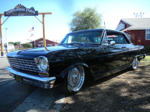 1997 Ford Ranger - Black 1966 Chevrolet Nova with chrome wheels parked outside Centennial Farm.