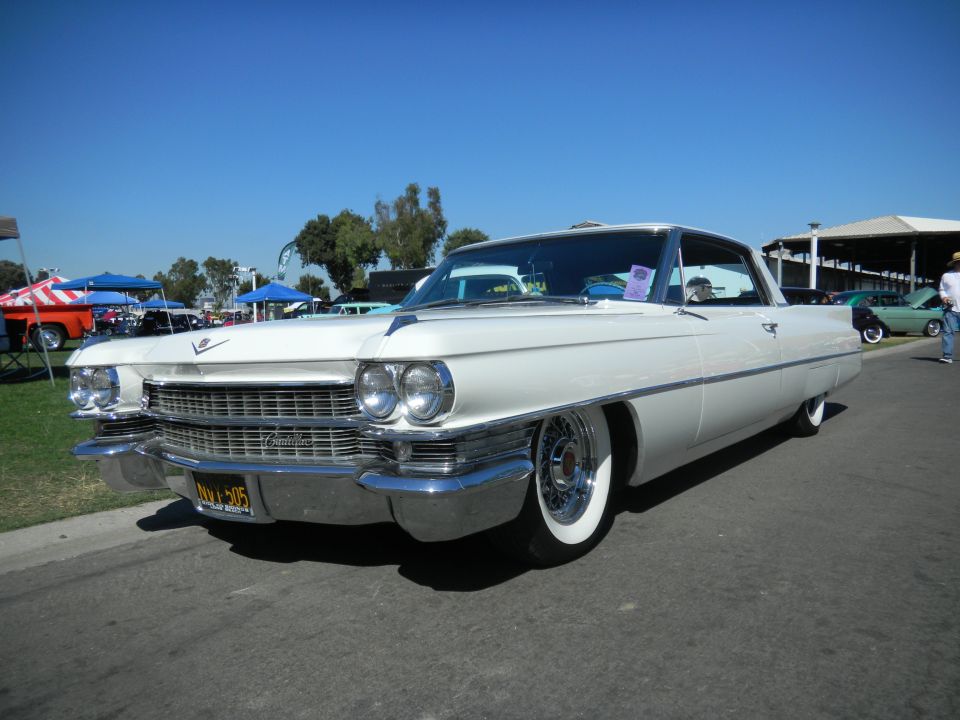White classic Cadillac coupe with wide whitewall tires and chrome grille