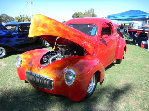 1997 Ford Ranger - A red coupe with flame graphics is displayed with its hood open at an outdoor car show.